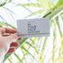 GIFT CARD held up against a bunch of palm leaves