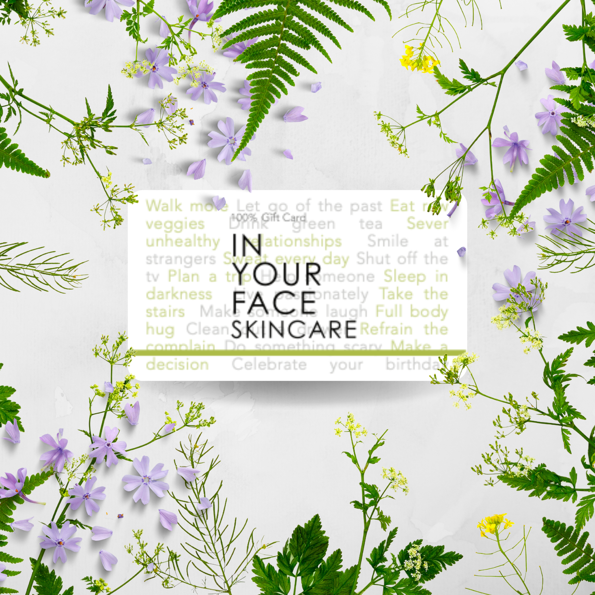an image of a gift card on a white background that says "100% Gift Card, IN YOUR FACE SKINCARE". In the background is a bunch of ferns and purple delicate flowers
